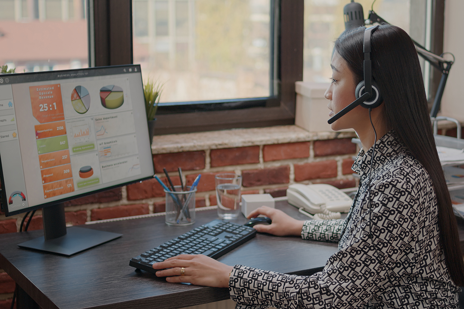 Close up of asian woman with headphones talking on phone call to people at customer service. Consultant using headset and microphone, working at call center on computer. Support chat